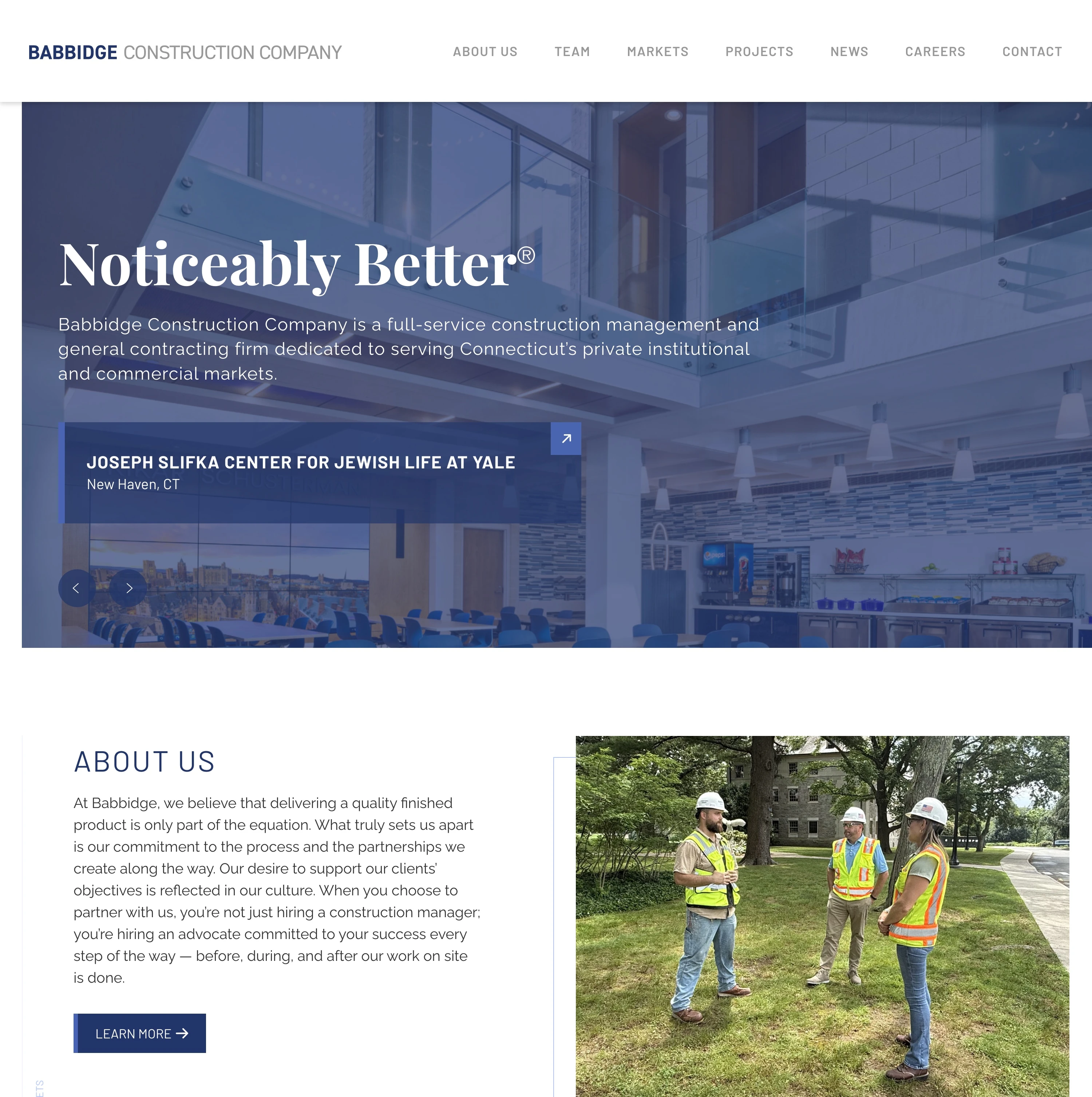 Babbidge Construction homepage — a dining hall interior under a blue overlay behind the headline “Noticeably Better®” and a slide for the Joseph Slifka Center for Jewish Life at Yale, above an About Us section beside a photo of three project staff in hard hats and safety vests