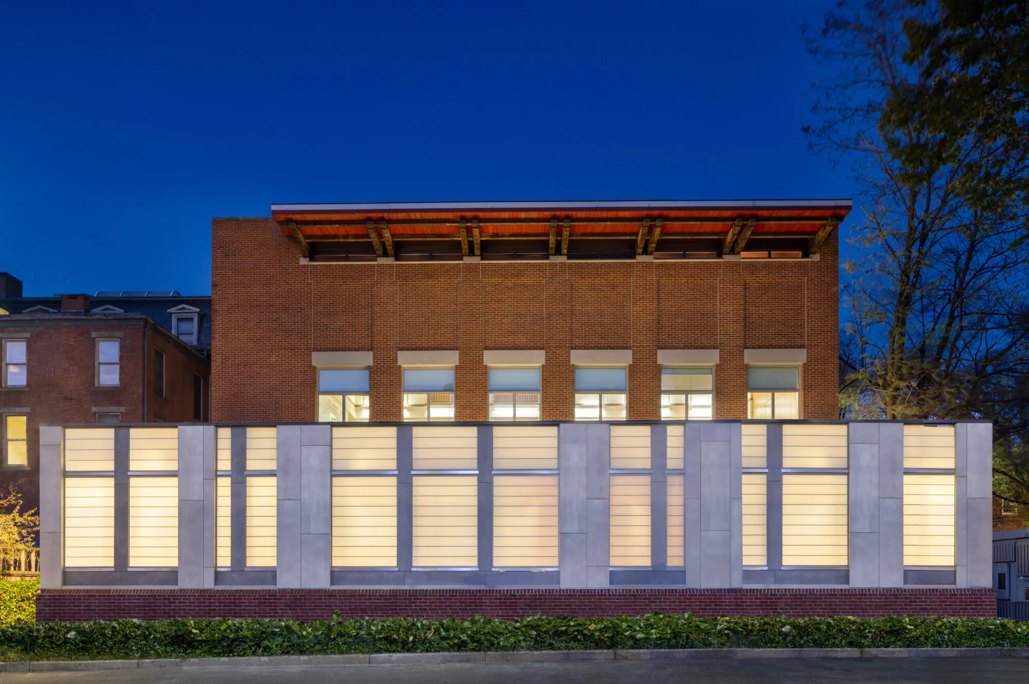 The Joseph Slifka Center for Jewish Life at Yale at dusk, a brick building rising behind a long street-front screen of glowing translucent panels — cover image for the Babbidge Construction website project