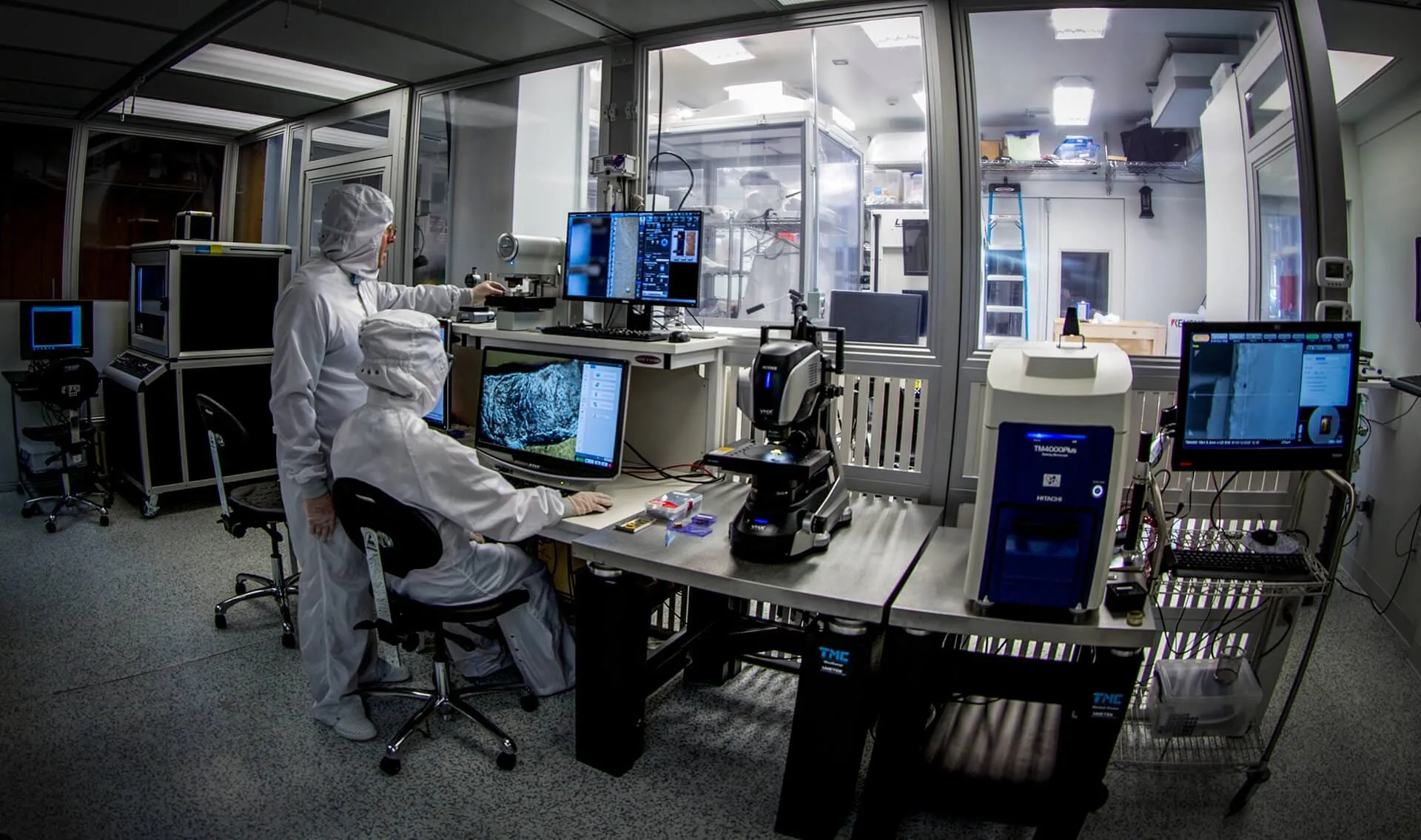 Technicians in cleanroom suits working at microscopes and monitors inside a laboratory — cover image for the MicroCircuit Laboratories website project